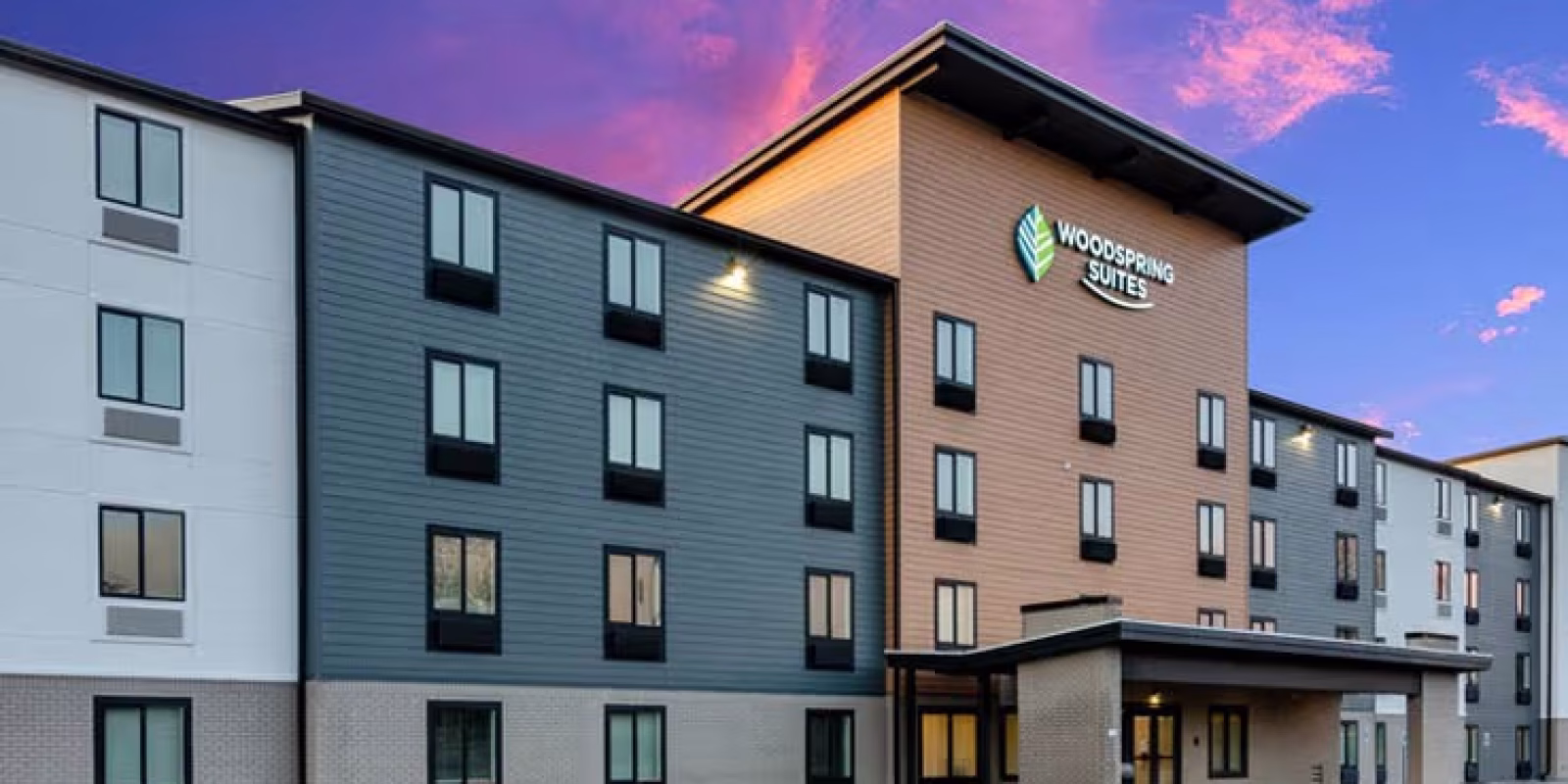 WOODSPRING-SUITES-TCOMALAKEWOOD-EXTENDED-STAY-HOTEL-EXTERIOR-DUSK-2-738X456
